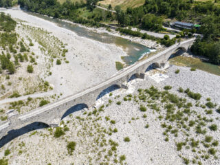 Aerial View. Drought And Dry Rivers. Roman Bridge Of Bobbio Over The Trebbia River, Piacenza, Emilia Romagna. Italy