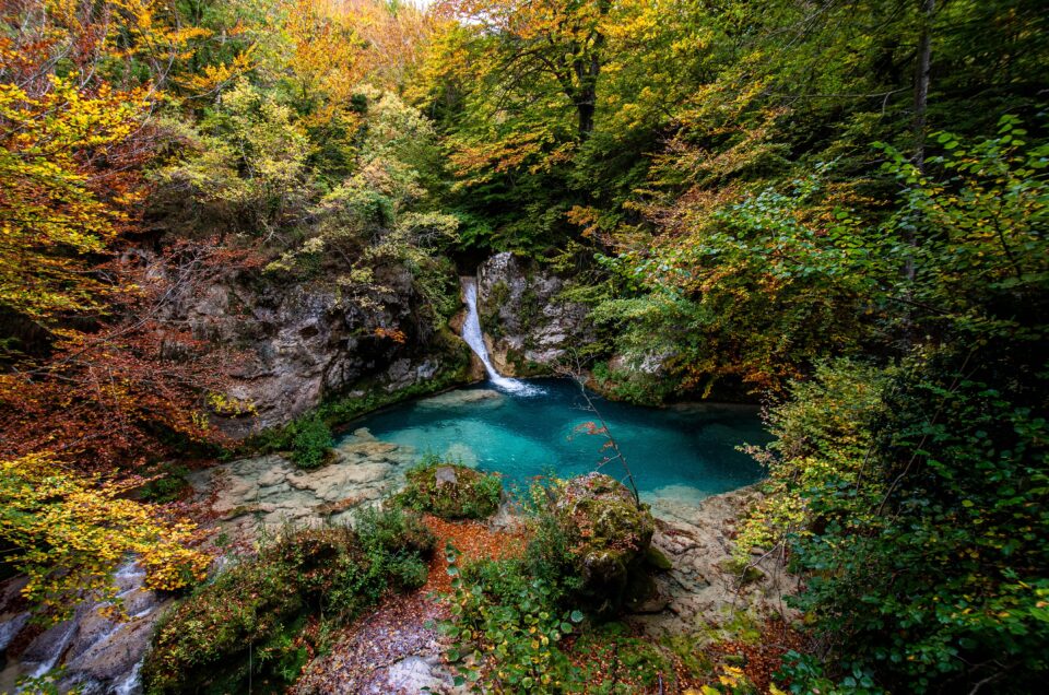 Forest,turquoise,blue,lake,with,white,marble,stones,and,waterfalls